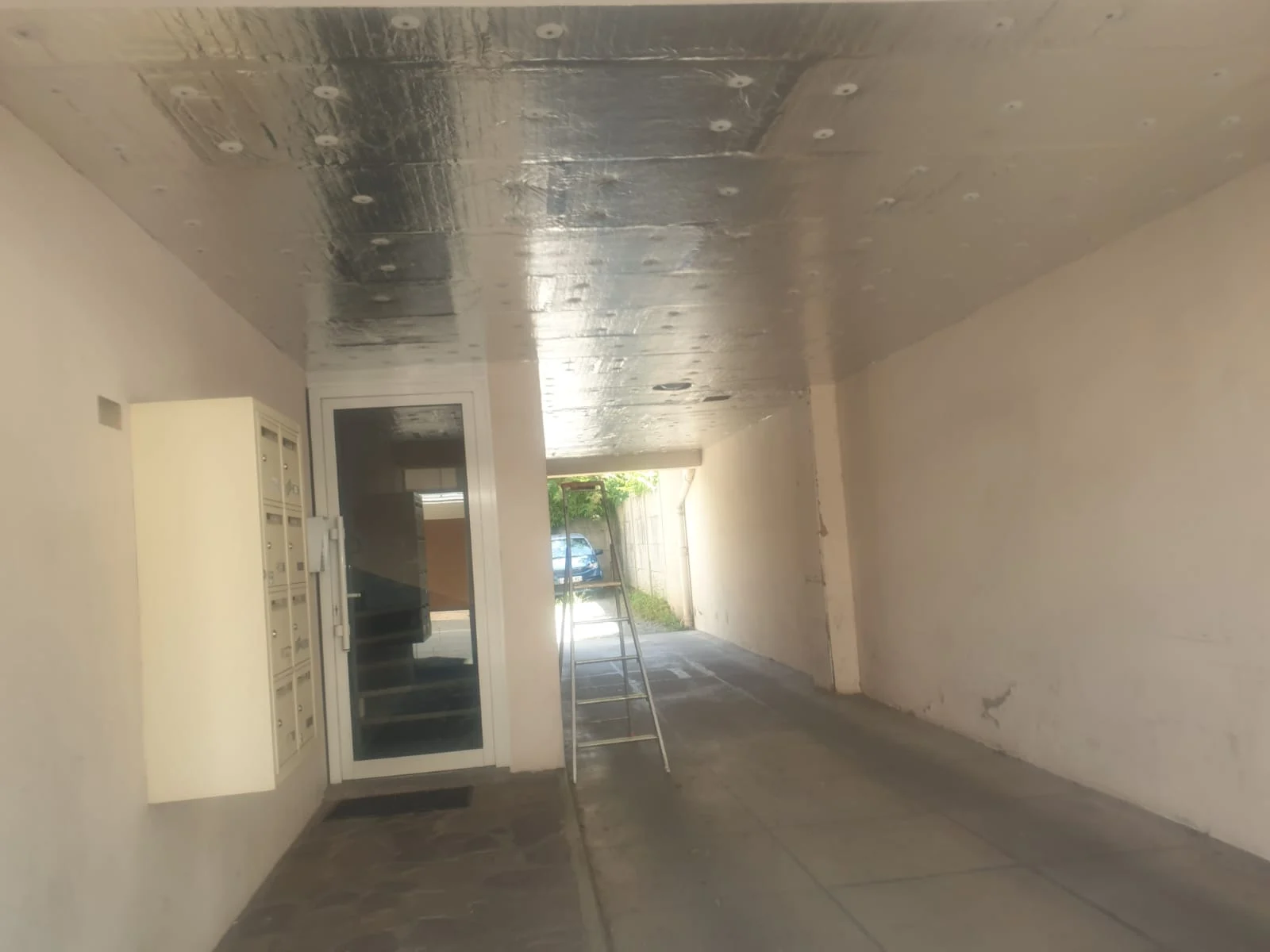 Sous-face de plancher isolée dans un passage de bâtiment